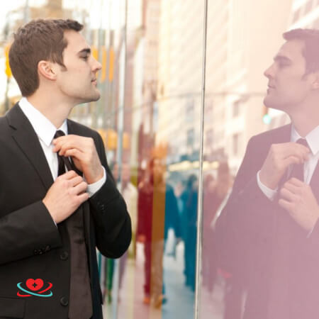 Проявление психопатии у мужчины Мужчина разглядывает себя в окне